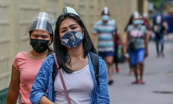 Người dân đeo khẩu trang và mặt nạ chống giọt bắn trên đường phố Manila, Philippines.