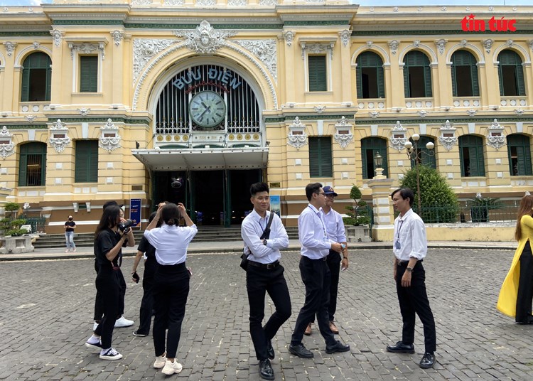 Một nhóm bạn trẻ không đeo khẩu trang tại khu vực trước Bưu điện Trung tâm TP Hồ Chí Minh, ngày 26/4. Ảnh: Hoàng Tuyết/Báo Tin tức