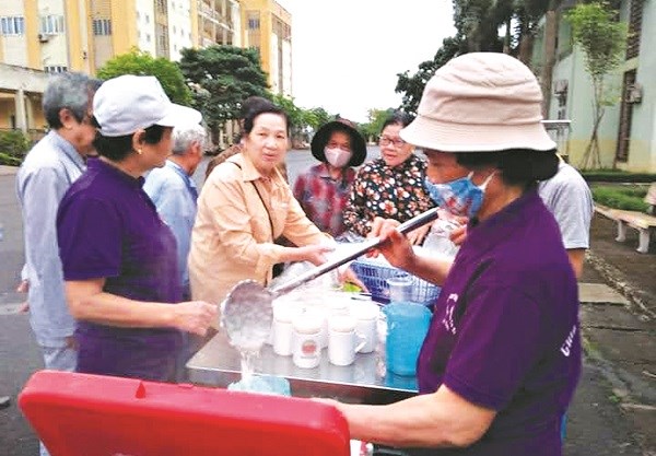 Bà Nguyễn Thị Hòa cùng các chị em trong chi hội phát cháo miễn phí cho các gia đình có hoàn cảnh  khó khăn