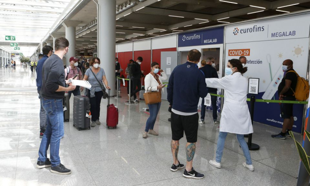 Hành khách xếp hàng bên ngoài địa điểm xét nghiệm COVID-19 tại sân bay Son Sant Joan, Tây Ban Nha.