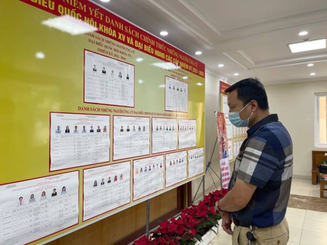 Cử tri theo dõi thông tin về các ứng cử viên đại biểu Quốc hội và Hội đồng nhân dân tại một điểm bầu cử của quận Hoàn Kiếm. Ảnh: Gia Huy