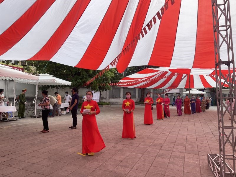 Phụ nữ quận Thanh Xuân thực hiện bỏ phiếu trong những bộ áo dài sắc đỏ có ngôi sao vàng