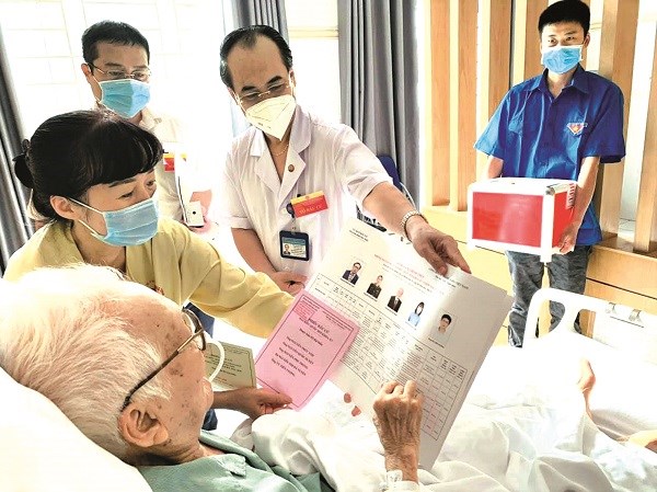 GS.TS Nguyễn Đình Hường (92 tuổi) - nguyên Viện trưởng Viện Lao và bệnh phổi, đang điều trị tại BV Phổi TƯ vui vẻ, phấn khởi tham gia bỏ phiếungay tại giường bệnh. 	Ảnh: BS Phương Anh