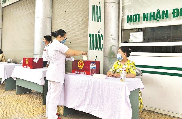 Chị Trần Thị Kim Anh Chủ tịch HLHPN phường Phương Mai quận Đống Đa hỗ trợ công tác bỏ phiếu tại bệnh viện Bệnh Nhiệt đới Trung ương. Ảnh: NVCC