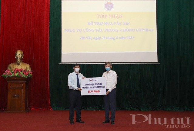 Tổng giám đốc EVN Trần Đình Nhân trao số tiền hỗ trợ Quỹ Phòng chống vắc xin Covid-19 cho Bộ trưởng Bộ Y tế Nguyễn Thanh Long.