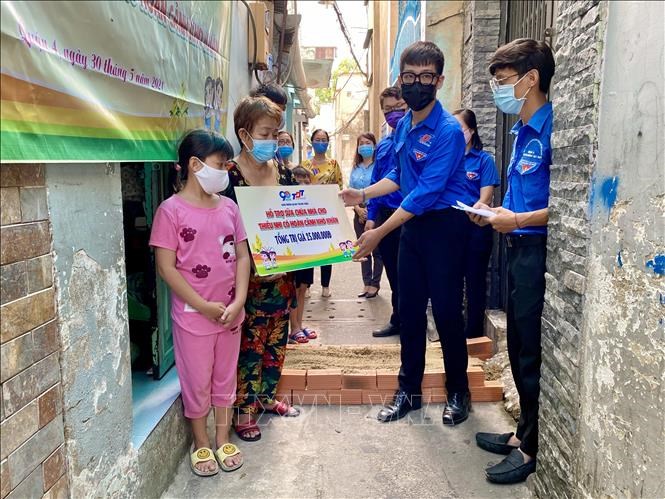 Trao bảng tượng trưng công trình sửa chữa nhà cho thiếu nhi có hoàn cảnh khó khăn cho người dân tại Phường 14, Quận 4 (Thành phố Hồ Chí Minh) vào ngày 30/5. Ảnh: TTXVN
