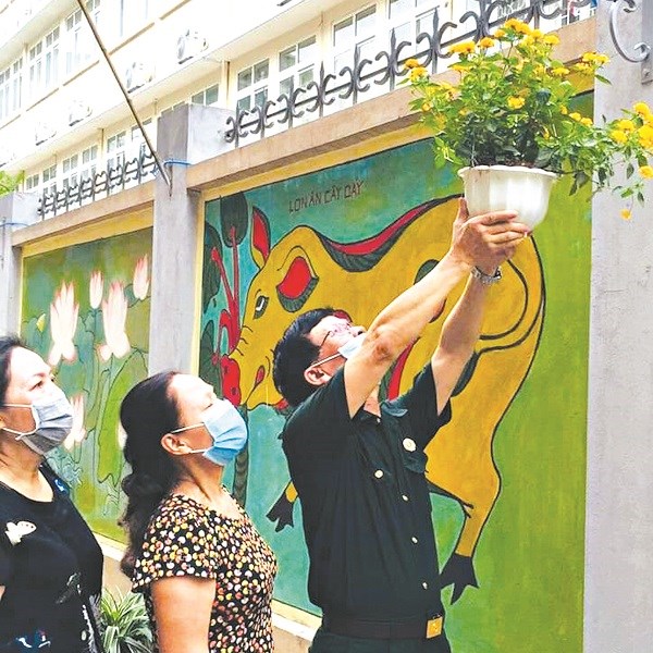 Chị em cán bộ hội, Hội Cựu chiến binh tham gia treo các giỏ hoa lên trên các bức tường bích họa tại Ngõ Quỳnh