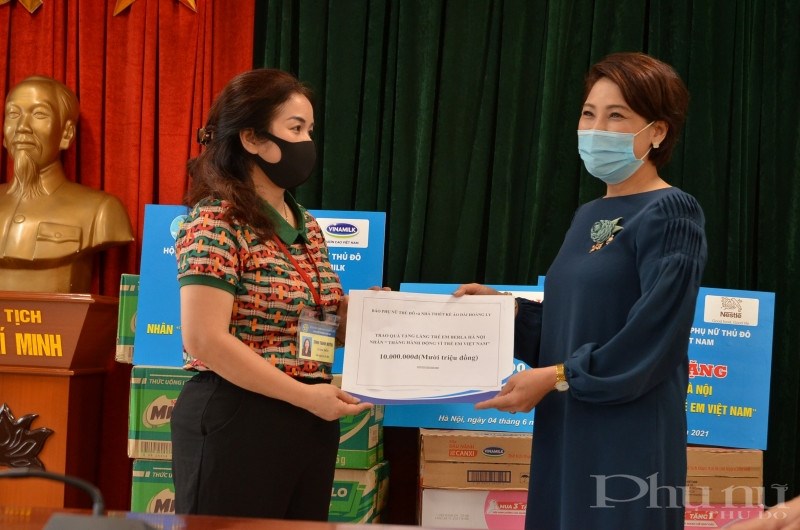 Bà Lê Quỳnh Trang - TBT Báo Phụ nữ Thủ đô trao số tiền hỗ trợ 10 triệu đồng của NTK áo dài Hoàng Ly cho đại diện Làng trẻ Birla Hà Nội. (Ảnh: Công Ngọc)