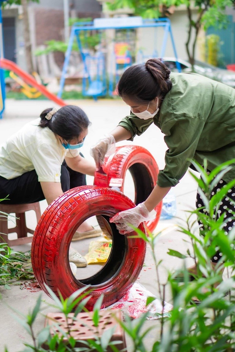 Chị em hội viên phụ nữ sơn những lốp xe cũ để tạo thành các bồn trồng hoa