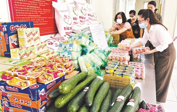 Cán bộ Hội phụ nữ phường Kim Liên đang tập kết hàng hoá, lương thực hỗ trợ người dân tổ dân phố 11