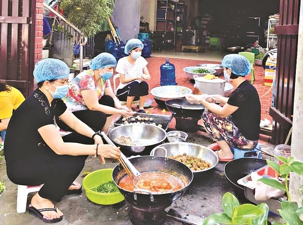 Chị em cán bộ Hội viên Phụ nữ và các thành viên nhóm thiện nguyện Triều Khúc nấu cơm phục vụ các chốt dịch và bệnh nhân tại bệnh viện K3 Tân Triều