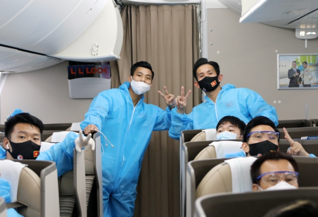 Trên chuyến bay trở về Việt Nam, đội tuyển được bố trí tại một khoang riêng, mặc trang bị phòng hộ trong suốt hành trình bay và cho tới khi về tới địa điểm cách ly tập trung y tế. Ảnh VFF