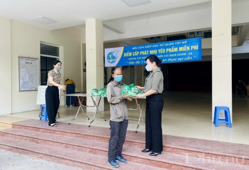 Chị Bùi Thị Ngọc Thúy - Chủ tịch Hội LHPN quận Tây Hồ tặng nhu yếu phẩm cho hộ dân khó khăn trên địa bàn.