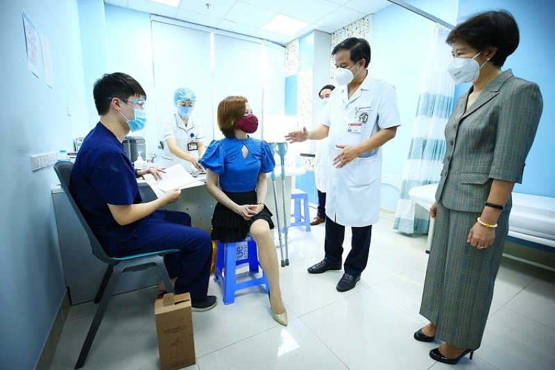 PGS.TS Đào Xuân Cơ (áo trắng) và bà Nguyễn Thị Bích Ngọc (ngoài cùng, bên phải) thăm hỏi, động viên người tiêm trước khi được tiêm vắc xin phòng Covid-19.
