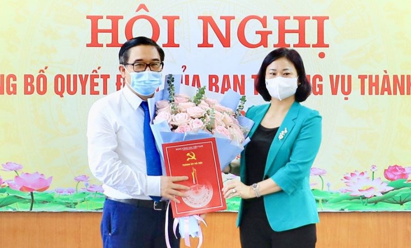 Phó Bí thư Thường trực Thành ủy Hà Nội Nguyễn Thị Tuyến trao Quyết định của Ban Thường vụ Thành ủy và tặng hoa chúc mừng đồng chí Đỗ Đình Hồng.