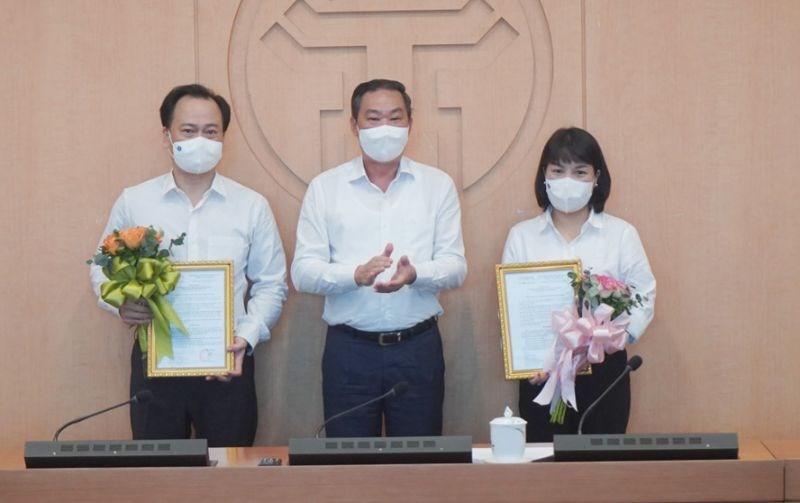 Đồng chí Lê Hồng Sơn trao quyết định và tặng hoa hai đồng chí tân Phó Chánh Văn phòng UBND thành phố.