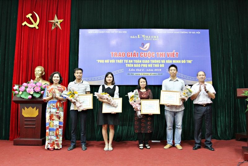 Nhà báo Kiều Thanh Hùng (người ngoài cùng bên phải) trao giải cho các tác giả đạt giải tại cuộc thi “Phụ nữ với an toàn giao thông và văn minh đô thị”