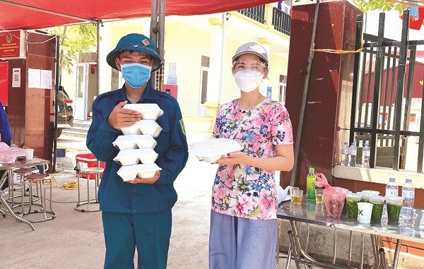 Chị Tạ Thị Hạnh (SN 1989, hội viên phụ nữ phường Tây Tựu, quận Bắc Từ Liêm) tặng những suất cơm ấm nóng cho các lực lượng tuyến đầu chống dịch
