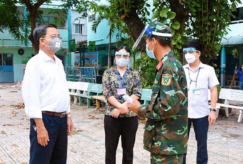 Đại diện cán bộ UBND Phường 1, quận Tân Bình trao đổi công việc với chỉ huy của nhóm chiến sĩ giúp dân tại địa phương.