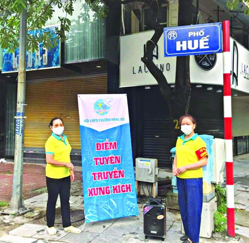 Cán bộ, hội viên phụ nữ phường Hàng Bài, quận Hoàn Kiếm tổ chức điểm tuyên truyền xung kích tại ngã tư Phố Huế 9 (trong đợt thực hiện giãn cách xã hội tháng 8).