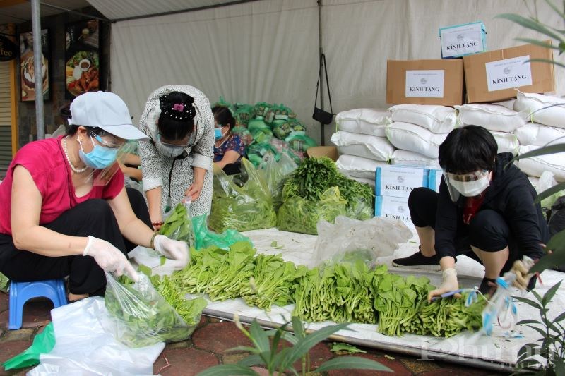 Cán bộ, hội viên phụ nữ phường Kim Đồng chia rau vào từng túi nhỏ để tặng người dân trong khu phong tỏa.