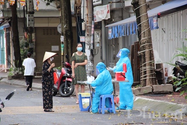 Cán bộ y tế lấy mẫu xét nghiệm cho người dân trong khu cách ly tại ngõ 24 Kim Đồng, phường Giáp Bát, Hoàng Mai, Hà Nội.