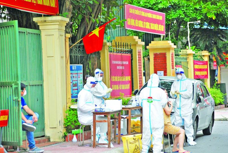 Lực lượng y tế lấy mẫu xét nghiệm cho người dân trong khu phong tỏa tại phường Thanh Xuân Trung. Ảnh: Thế Long