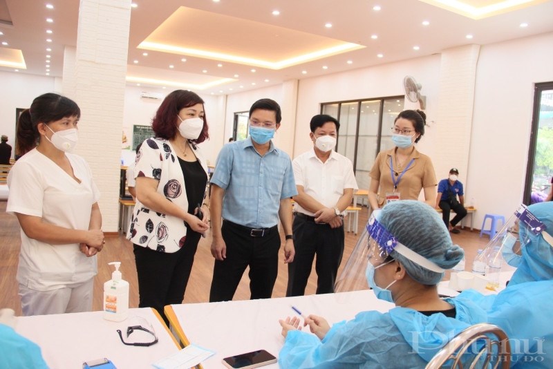 Đồng chí Lê Thị Thiên Hương (thứ 2 từ trái qua) trò chuyện, động viên các y bác sĩ đang làm nhiệm vụ tiêm chủng, xét nghiệm tại điểm tiêm.