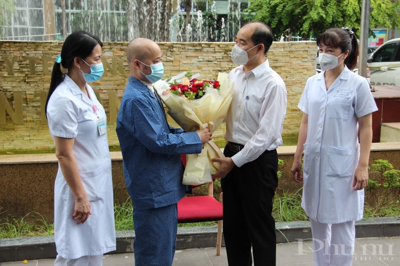 Lãnh đạo Sở Y tế Hà Nội và bệnh viện Đa khoa Thanh Nhàn tặng hoa chúc mừng bệnh nhân xuất viện.