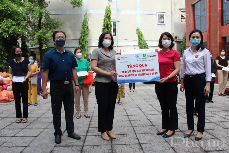 Chủ tịch Hội LHPN Hà Nội Lê Kim Anh (thứ 2 từ trái qua) và chị Yến - Phụ trách dự án Viện LIGHT thông qua Hội LHPN phường trao quà cho các nữ lao động di cư khó khăn.