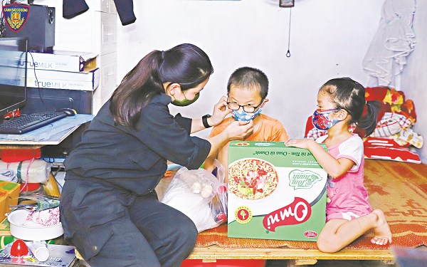Trung úy Lương Thị Thu trao quà cho các cháu nhỏ có hoàn cảnh khó khăn