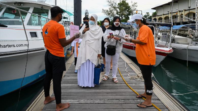 Hành khách quét mã ứng dụng để theo dõi tình trạng sức khỏe trước khi lên du thuyền ở Langkawi, Malaysia.
