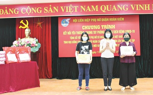 Đồng chí Trịnh Thị Huệ - Chủ tịch Hội LHPN quận Hoàn Kiếm tặng sổ tiết kiệm cho phụ nữ khó khăn.