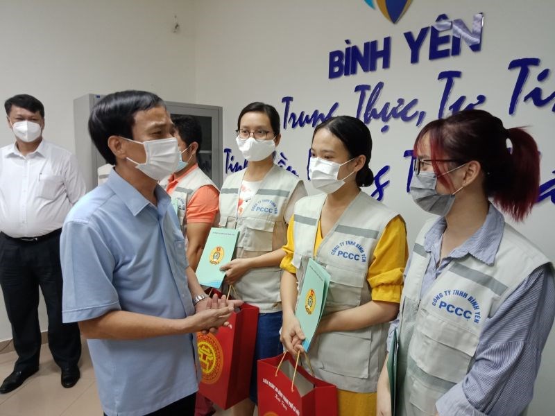 Phó Chủ tịch LĐLĐ thành phố Hà Nội Ngô Văn Tuyến (bên trái) lắng nghe những chia sẻ, niềm vui của người lao động khi được quay trở lại làm việc.