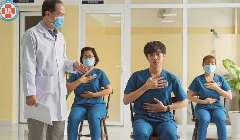 ThS.BS Calvin Q Trịnh Quang Anh (bệnh viện Chỉnh hình và Phục hồi Chức năng TP Hồ Chí Minh) hướng dẫn bài tập mở lồng ngực, kiểm soát nhịp thở cho bệnh nhân Covid-19 Ảnh: BVCC