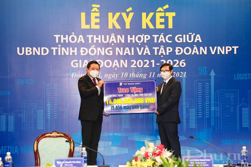 Tổng giám đốc VNPT Huỳnh Quang Liêm (bên trái) và Phó chủ tịch UBND tỉnh Đồng Nai Nguyễn Sơn Hùng (bên phải) thực hiện nghi lễ trao nhận 5.656 máy tính bảng.