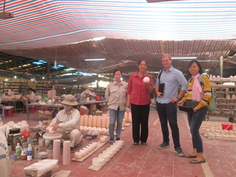 Bà Hà Thị Vinh (thứ 3 từ phải sang) giới thiệu các sản phẩm gốm sứ của công ty tới khách tham quan