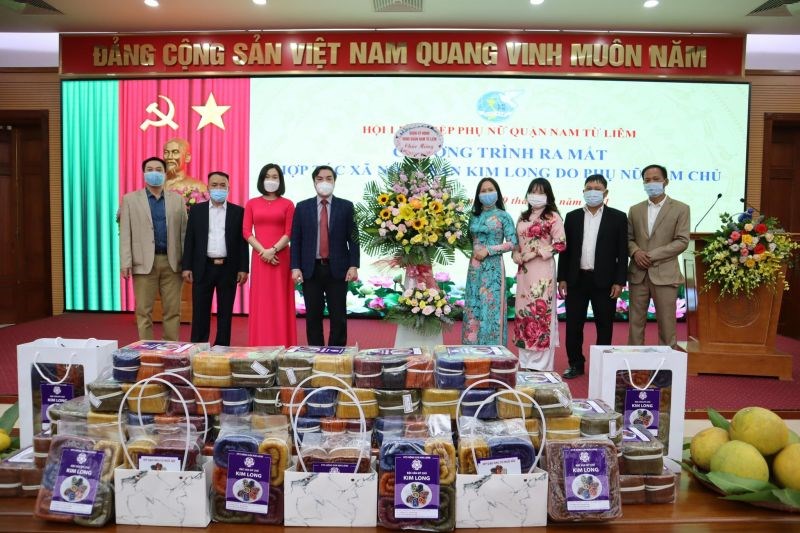 Đ/c Trần Thanh Hải, Trưởng ban Dân vận quận ủy Nam Từ Liêm (thứ 4 từ trái sang) tặng hoa chúc mừng HTX nông sản Kim Long ra mắt