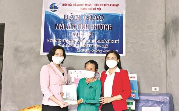 Chủ tịch Hội LHPN Hà Nội Lê Kim Anh (người đầu tiên bên trái) tặng quà trong buổi bàn giao Mái ấm tình thương cho gia đình chị Nguyễn Thị Dung thuộc diện hộ cận nghèo xã Minh Quang, huyện Ba Vì, Hà Nội.