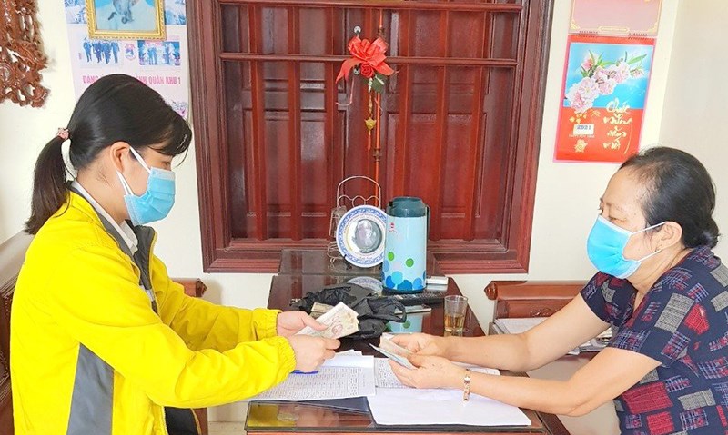 Cán bộ Bưu điện TP Hà Nội tri trả lương hưu tại nhà cho người dân.
