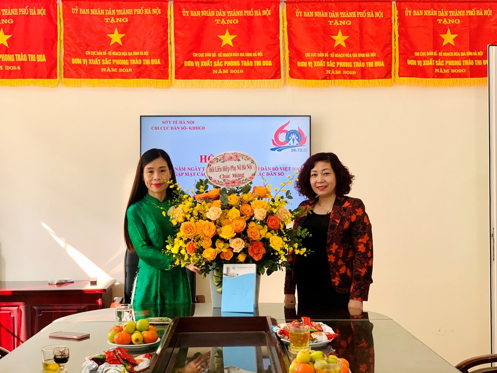 Bà Nguyễn Minh Xuân, Phó Chi cục trưởng Chi cục Dân số - KHHGĐ TP Hà Nội nhận lẵng hoa tươi thắm do Hội LHPN Hà Nội trao tặng