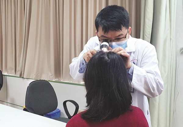 Ths.BSCKII Nguyễn Quang Minh thăm khám cho người bệnh rụng tóc sau khi khỏi Covid-19.Ảnh: BVCC