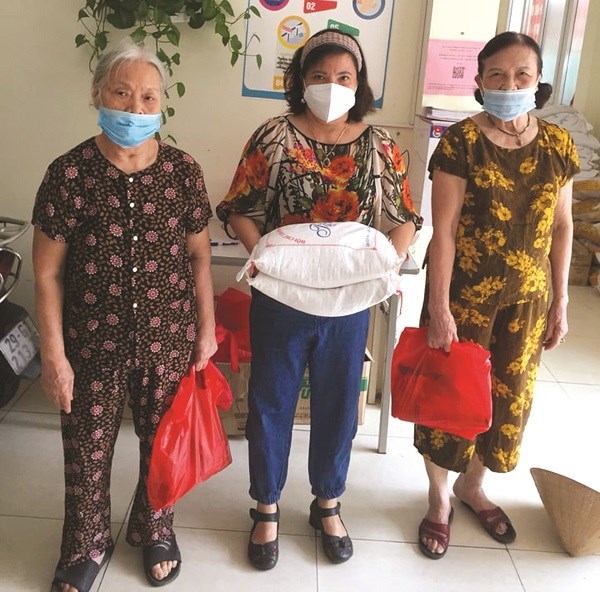 Chị Phạm Thị Cúc Tú (người đứng giữa) tặng quà cho hội viên phụ nữ trên địa bàn có hoàn cảnh khó khăn do dịch Covid-19