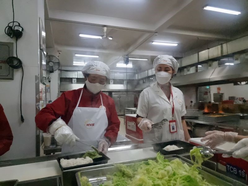 Chị Vũ Lan Sinh (bên phải) đang giám sát quá trình chế biến suất ăn của công ty Hương Việt Sinh