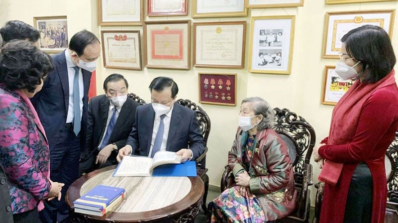 Bí thư Thành ủy Hà Nội Đinh Tiến Dũng và các đồng chí lãnh đạo thành phố xem cuốn sổ truyền thống của gia đình đồng chíNguyễn Phong Sắc	Ảnh: Viết Thành