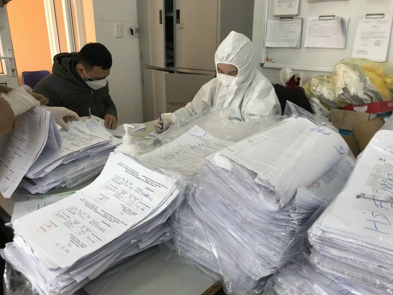 Cán bộ y tế phường Định Công xử lý giấy tờ khai báo của các F0 trên địa bànẢnh: Thảo Hương