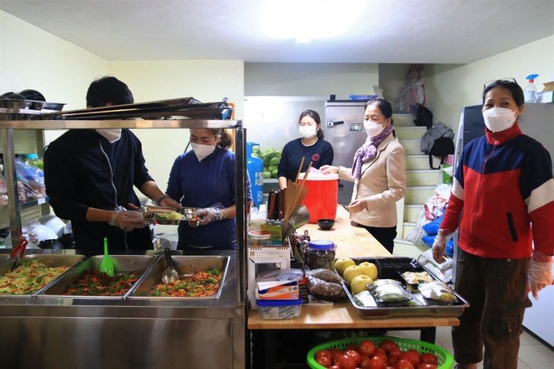 Trong gian bếp, tình nguyện viên nhóm Nhất Tâm luôn sẵn sàng phục vụ bữa ăn cho người dân 	Ảnh: Hà Lan