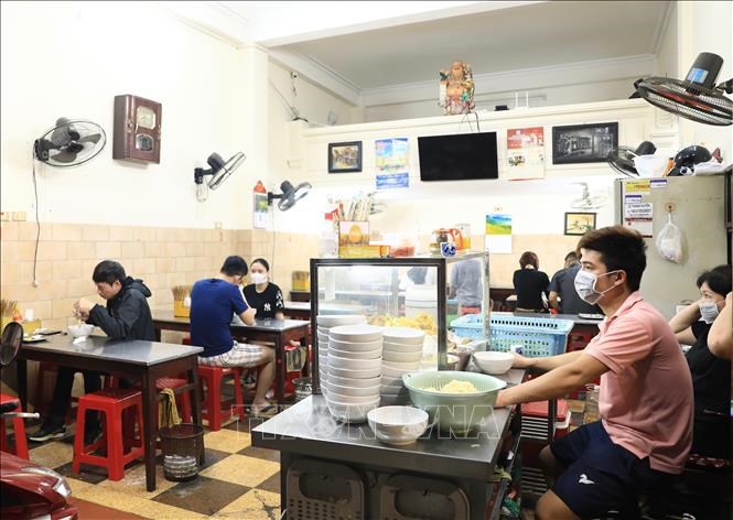 Một quán ăn trên phố Mai Hắc Đế (Hà Nội) đón khách lúc 20h30 ngày 15/3/2022. Ảnh: Hoàng Hiếu/TTXVN