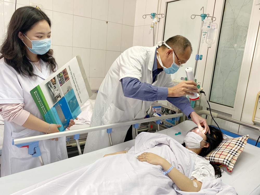 PGS.TS.BS Nguyễn Hồng Hà kiểm tra mức độ hồi phục ở mắt cho bệnh nhân gặp biến chứng sau khi tiêm filler. 	Ảnh: BVCC