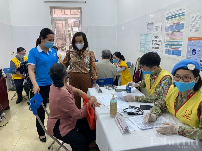 Đồng chí Lại Thị Hà Phương - Chủ tịch Hội LHPN quận Hà Đông (người đứng, bên phải) hỏi han, động viên một người tới khám bệnh.